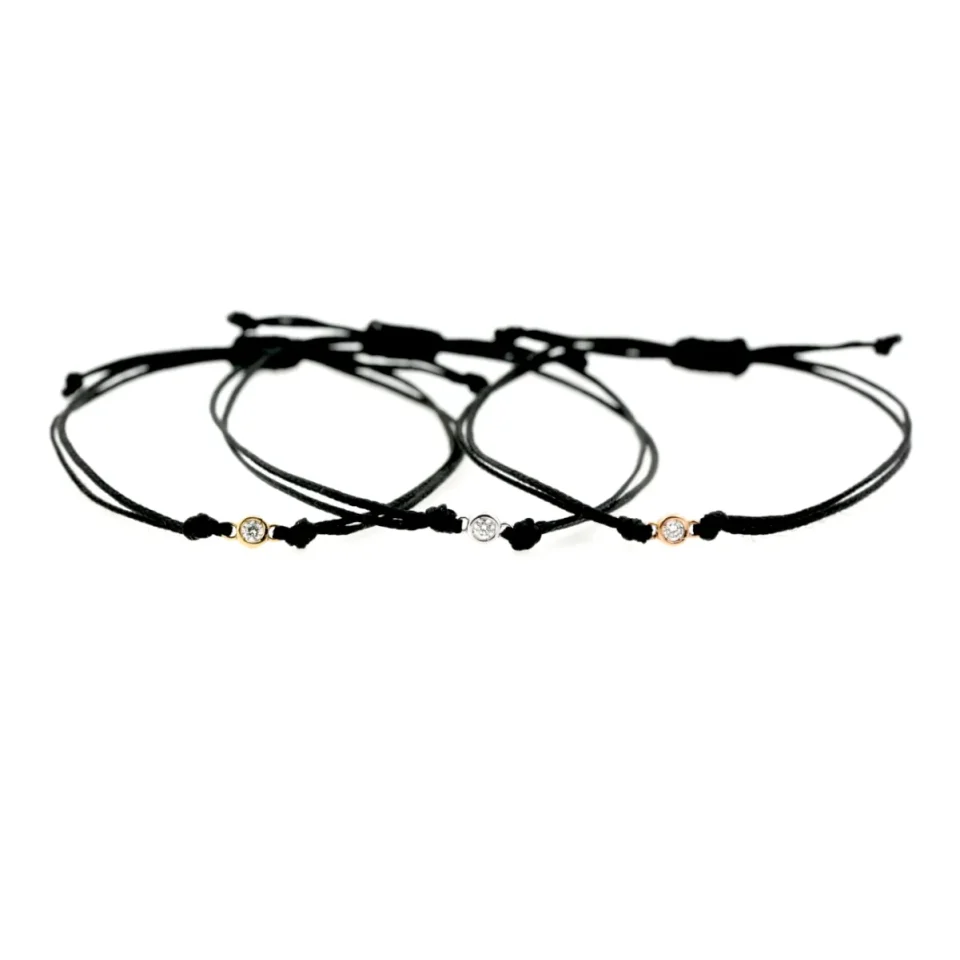 bracciali in cordino nero , diamante e tre ori