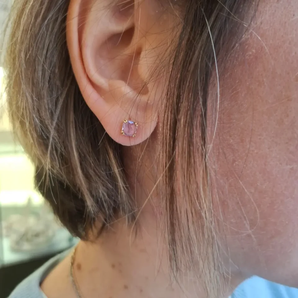 Orecchini in oro con cristalli viola indossati